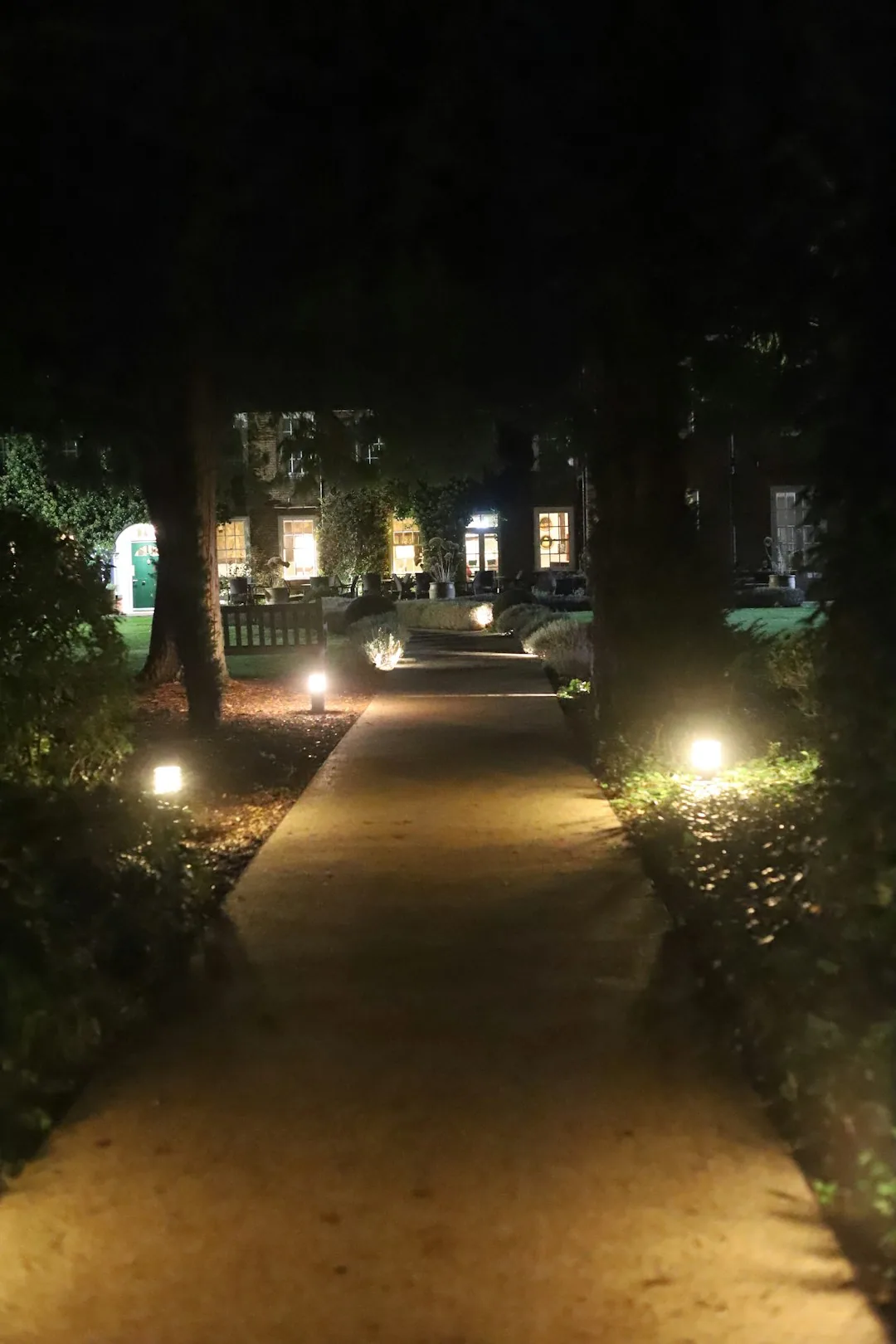Lit garden walkway toward glowing house windows night swansea SC